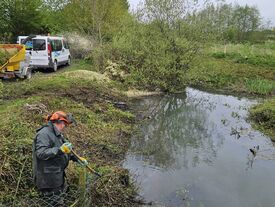 Un agent enlève des branches d'un cours d'eau